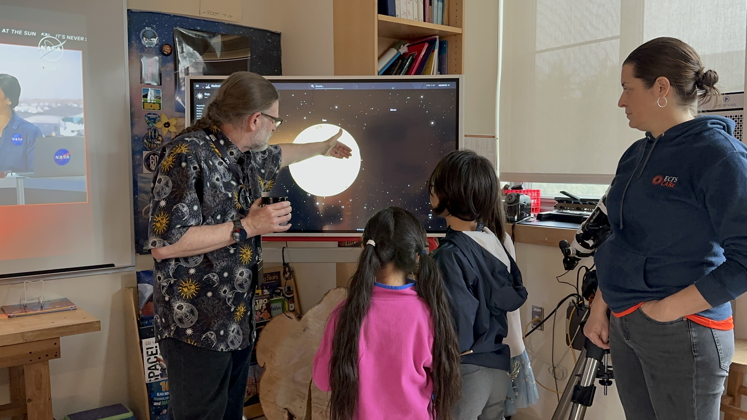 Wilkinson explaining the eclipse to students and a parent at Homecoming.