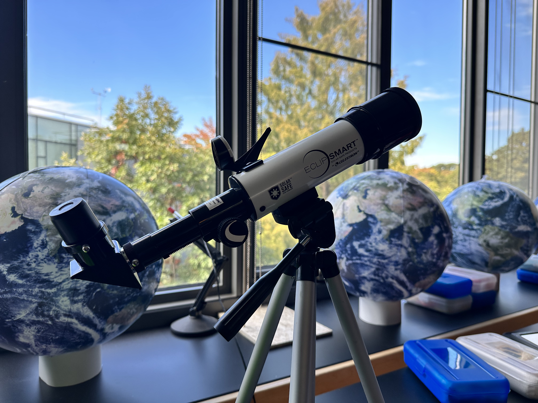 Photo of a telescope in Fieldston Lower classroom in front of window.