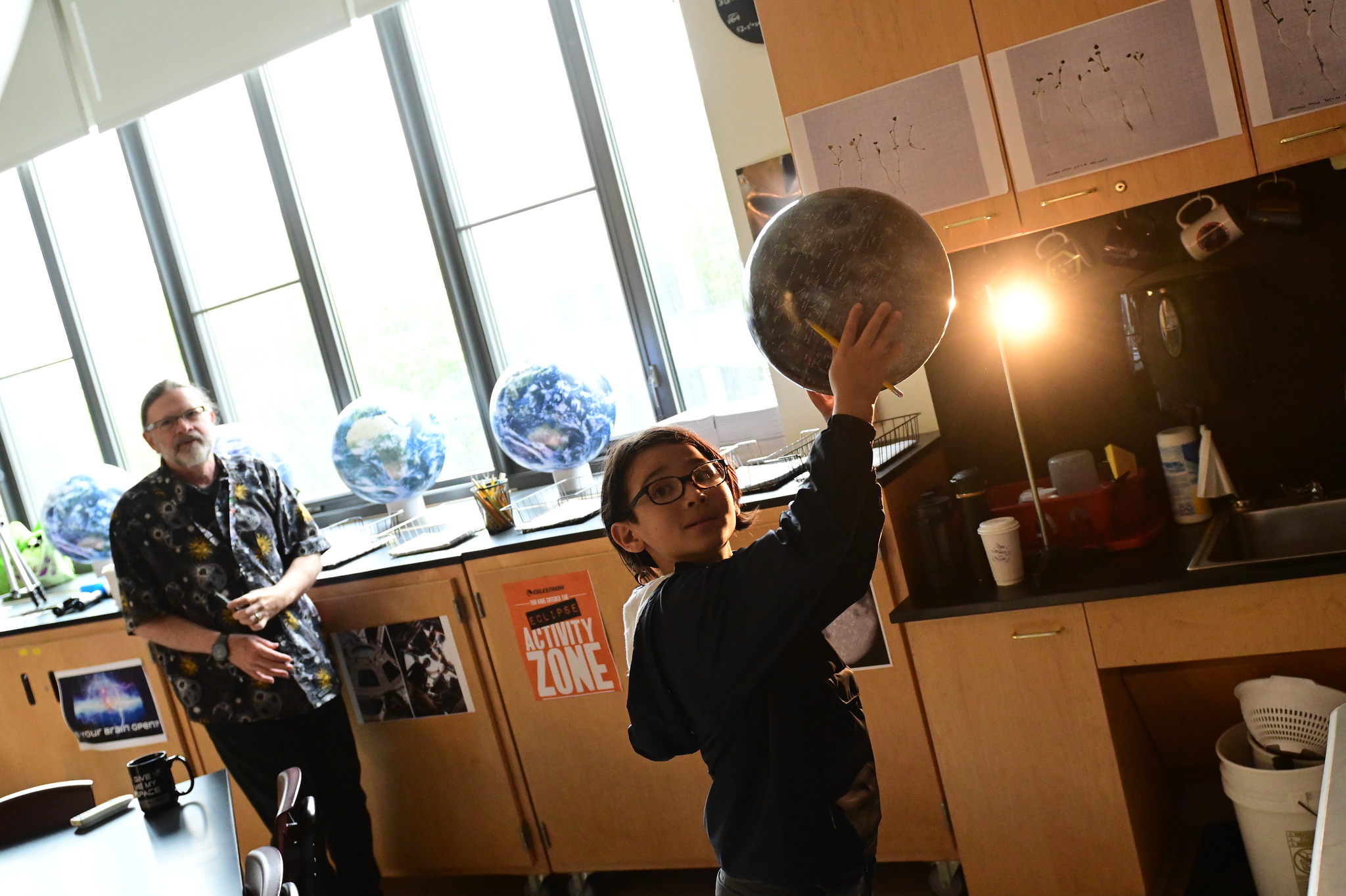 Fieldston Lower student tries out model of eclipse at Homecoming.