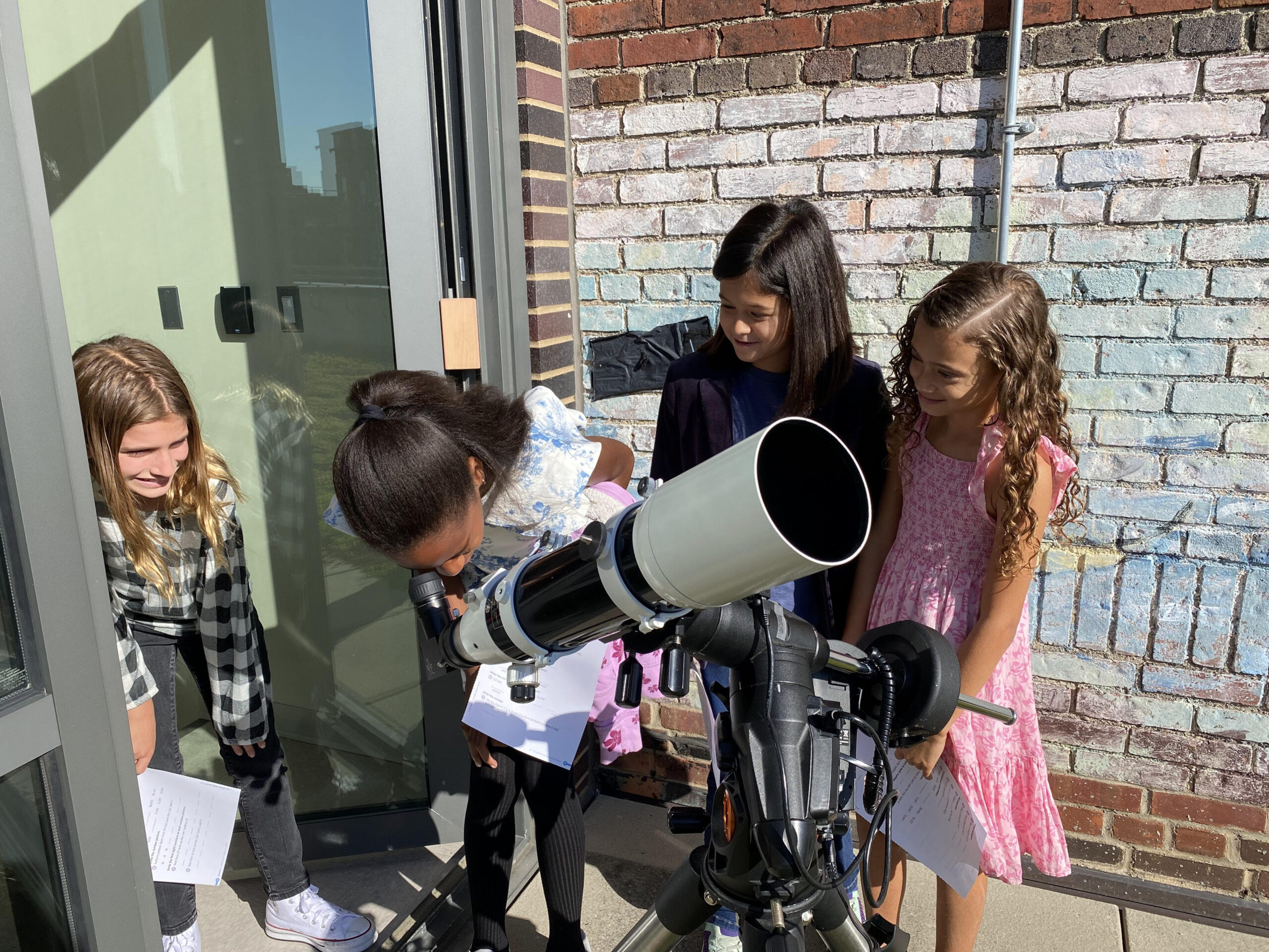 Fieldston Lower students observe the sky using a telescope.