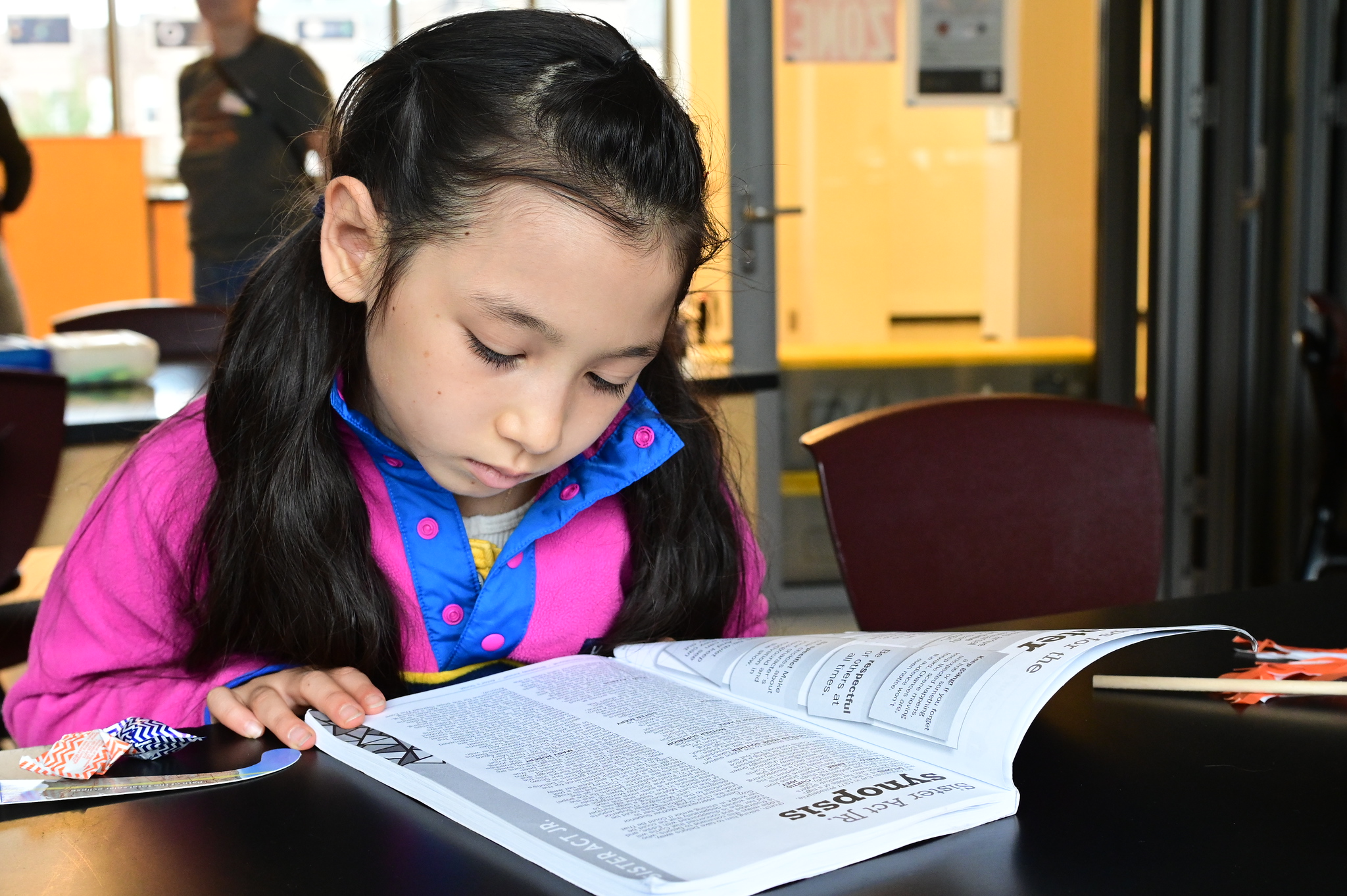 Fieldston Lower student looks through informational material at Homecoming.