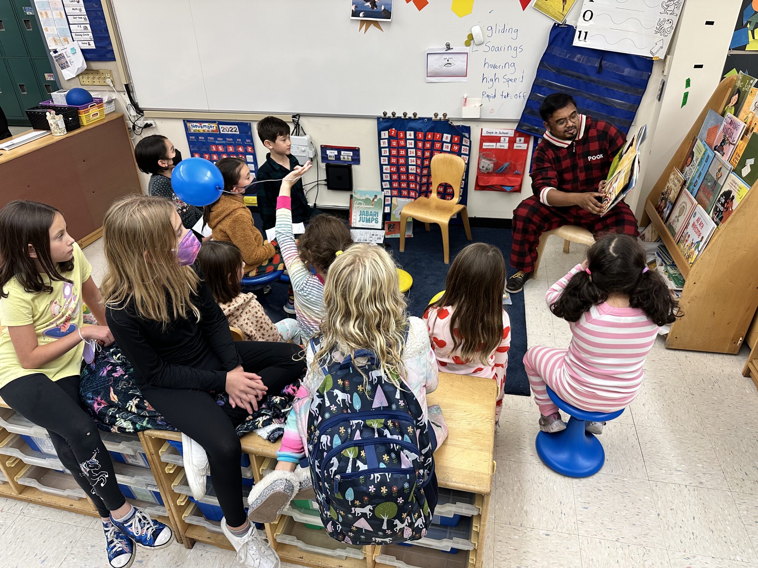 Fieldston Lower Assistant Principal Shawn Chisty reads to a room full of students; they sit on the floor in pajamas and listen along.