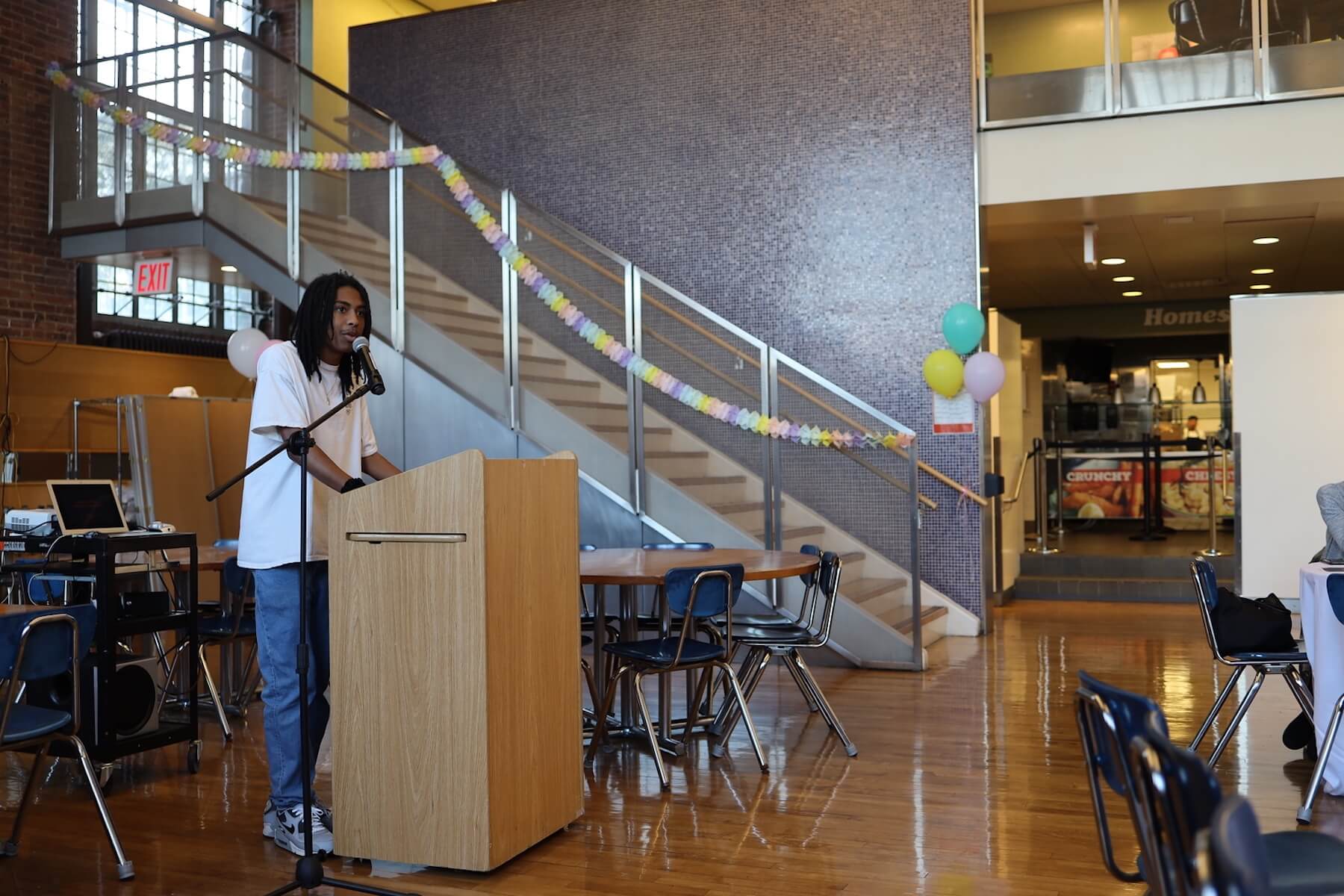 ECFS student speaks at podium at Bridge to Bridge year-end celebration in the Dining Hall.