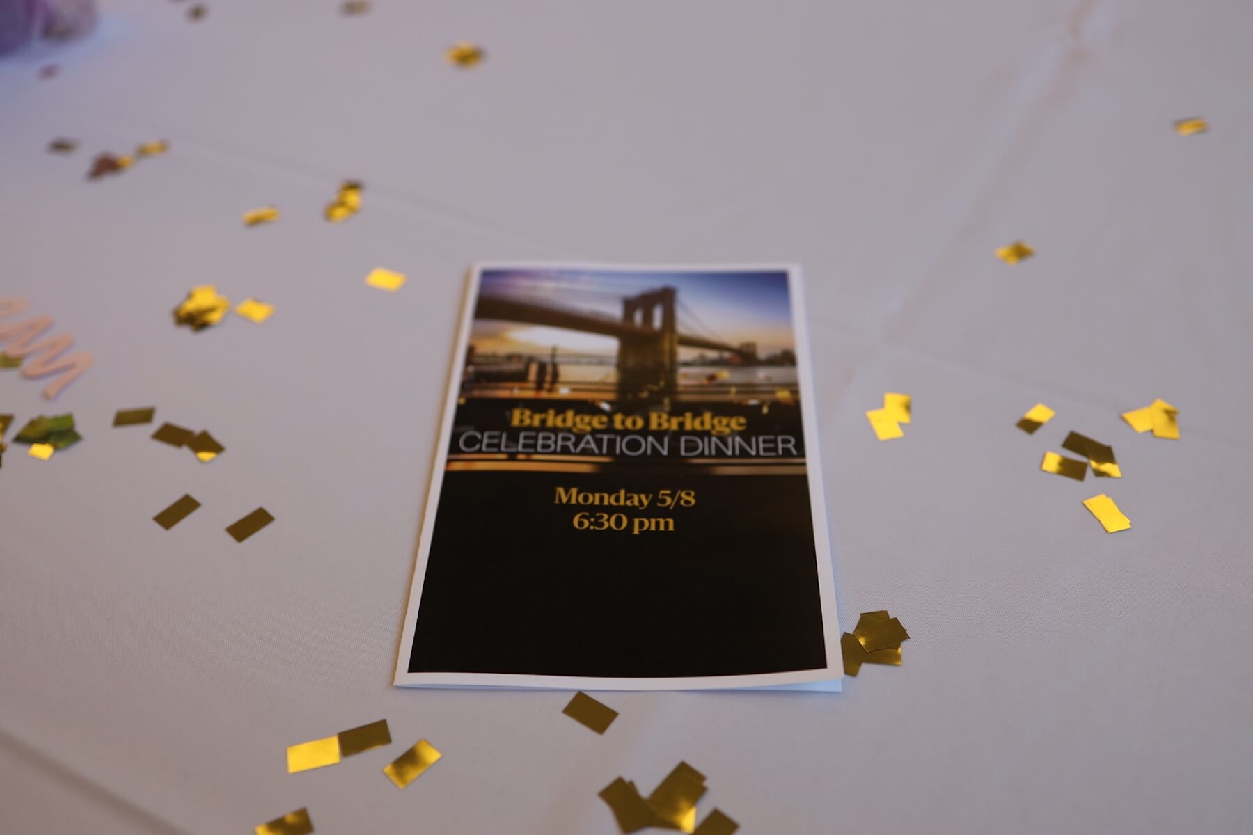 Photo of event program on table surrounded by gold confetti