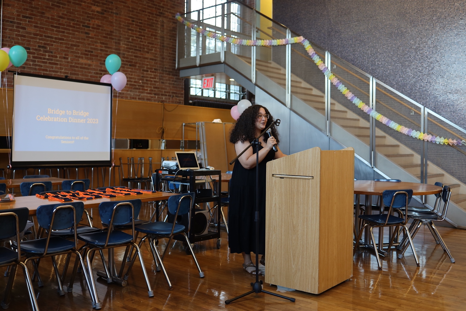 ECFS student speaks at podium at Bridge to Bridge year-end celebration in the Dining Hall.