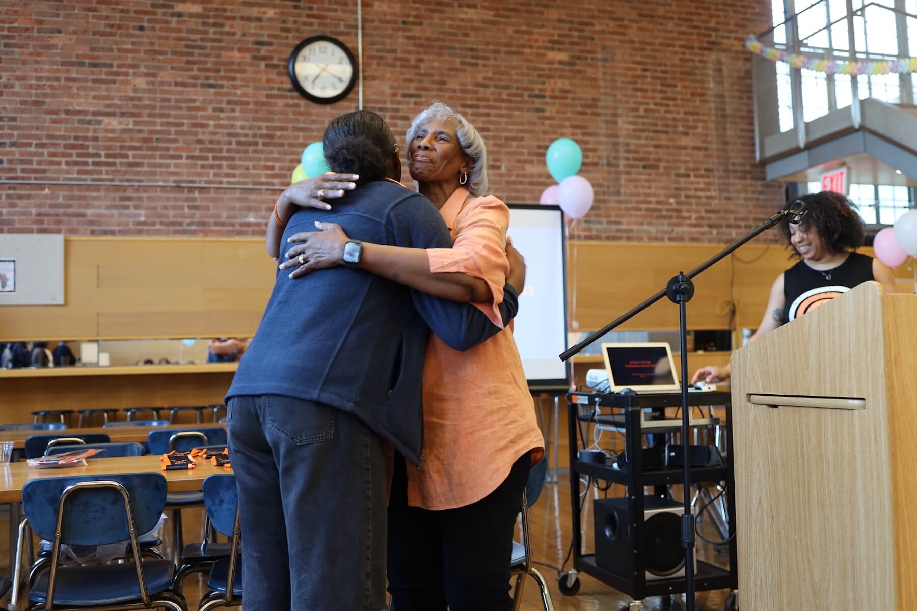 Bridge to Bridge faculty advisor Janet Pugh hugs Fieldston Upper senior.