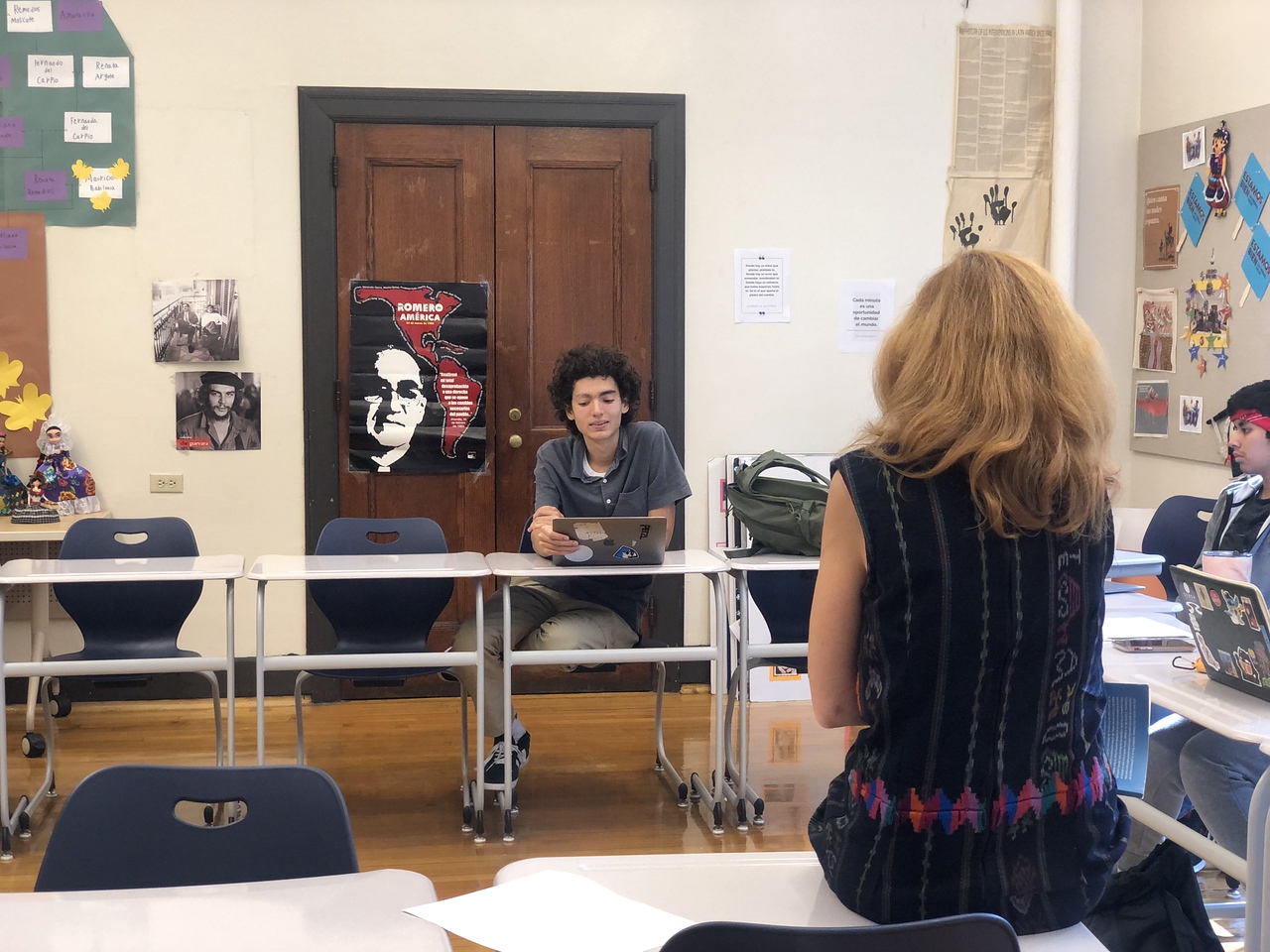 Fieldston Upper student sits at desks and discusses text with Spanish teacher Lorena Rodas-Ramirez