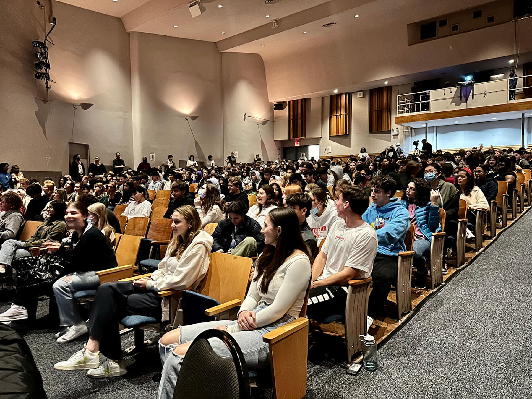 Students at Ethical Culture Fieldston School gather in auditorium for Veterans Day assembly. They sit in the auditorium seats, eyes facing the stage.