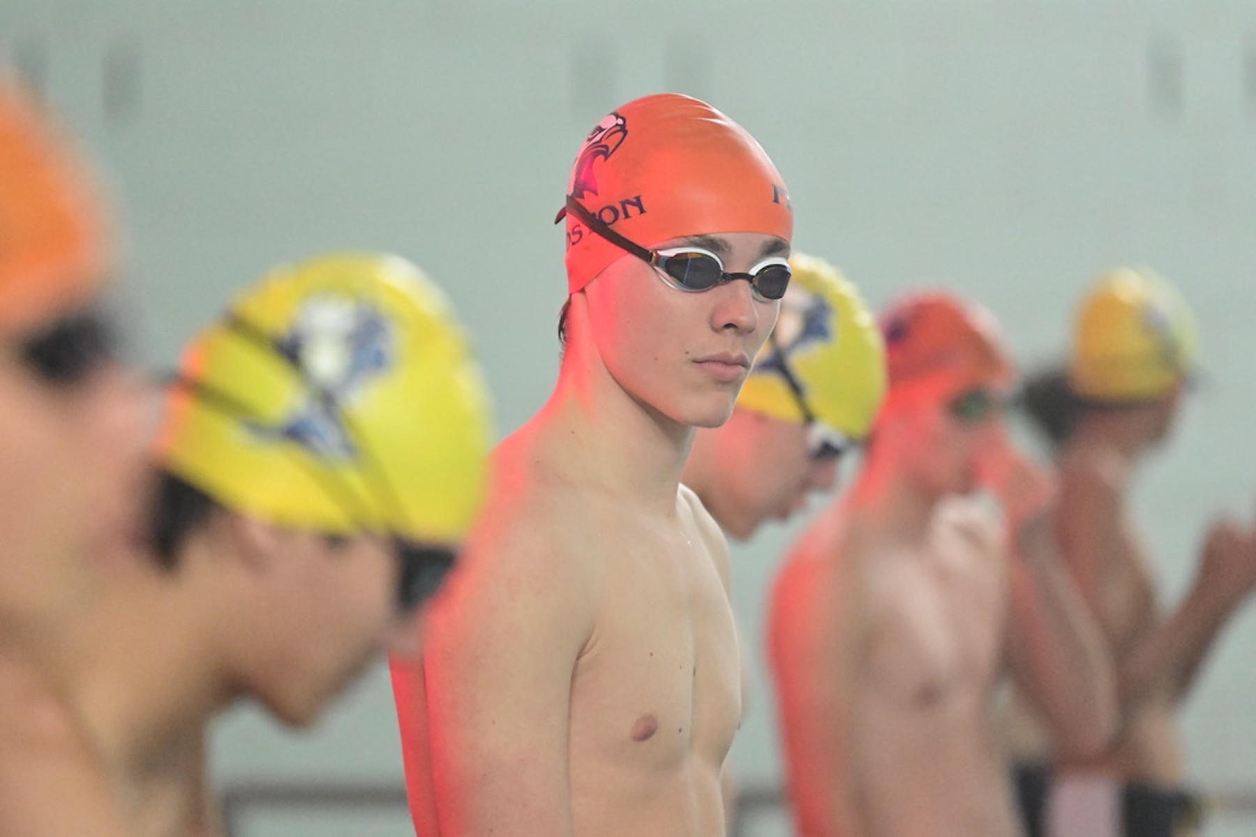 Fieldston Upper swimmer wearing swim cap and goggles looks to camera.