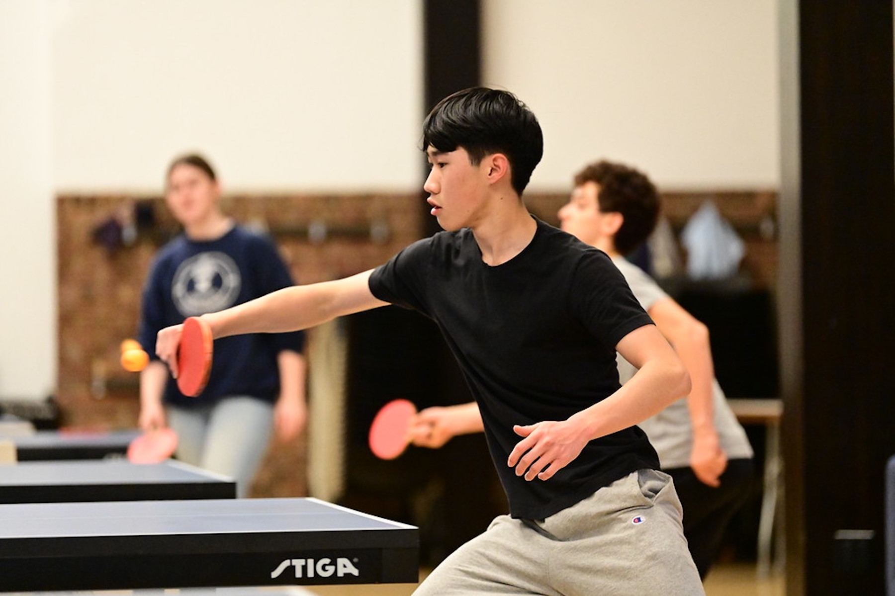 Fieldston Upper student practices table tennis in the Student Commons.