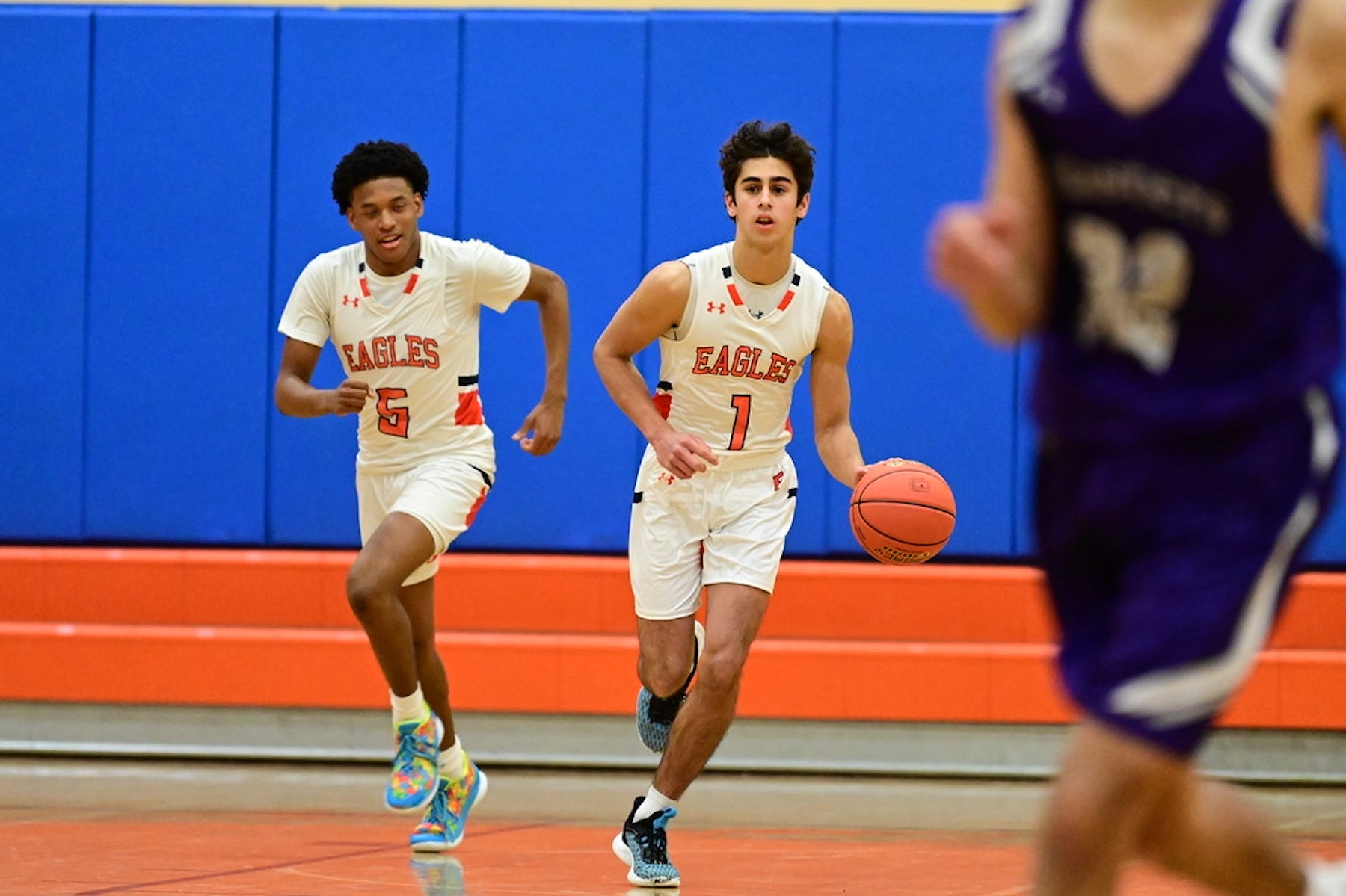 Fieldston Upper boys varsity basketball player dribbles the ball up the court.