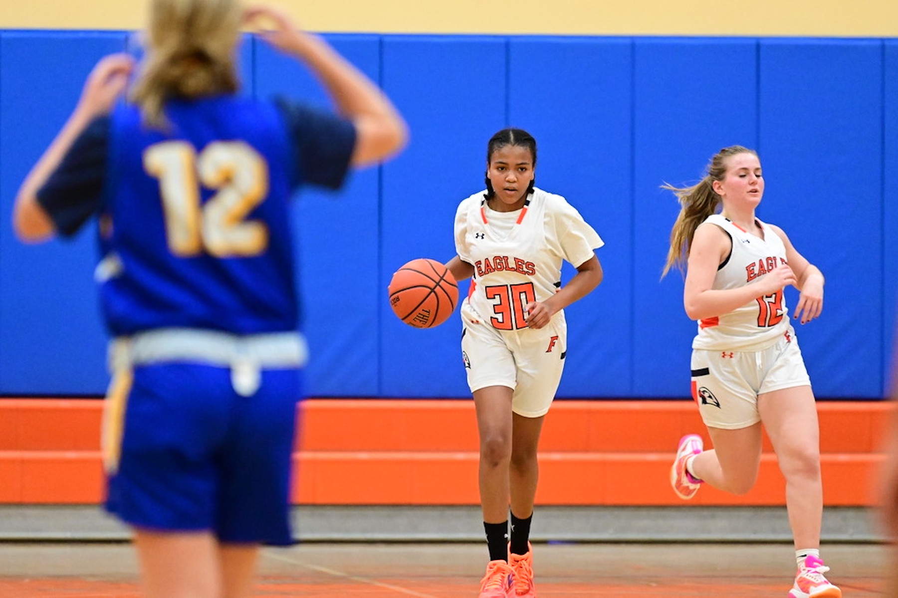 Fieldston Upper girls varsity basketball player dribbles the ball up the court.