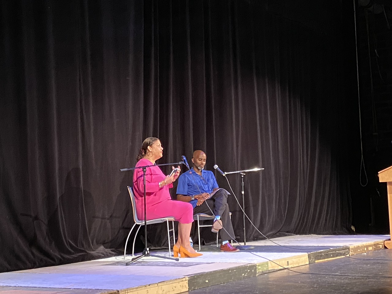 Alwin Jones sits on stage and moderates conversation with guest speaker in Fieldston Upper auditorium. 