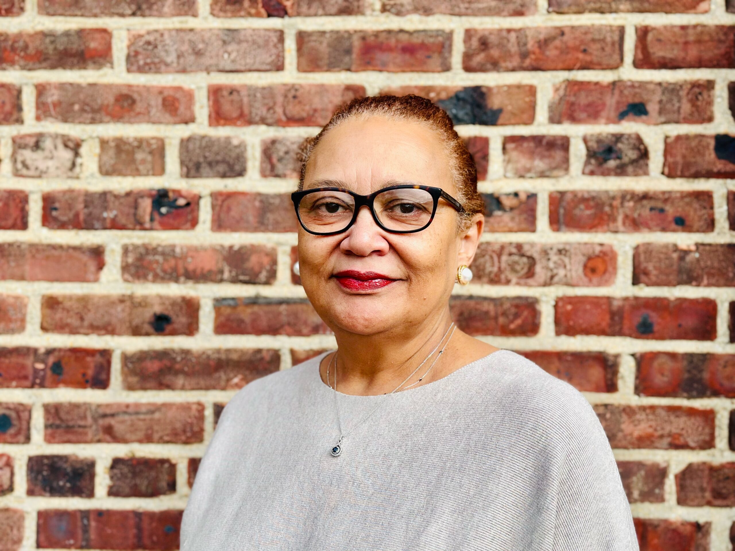 Director of Financial Aid  Victoria Daley stands in front of a brick wall