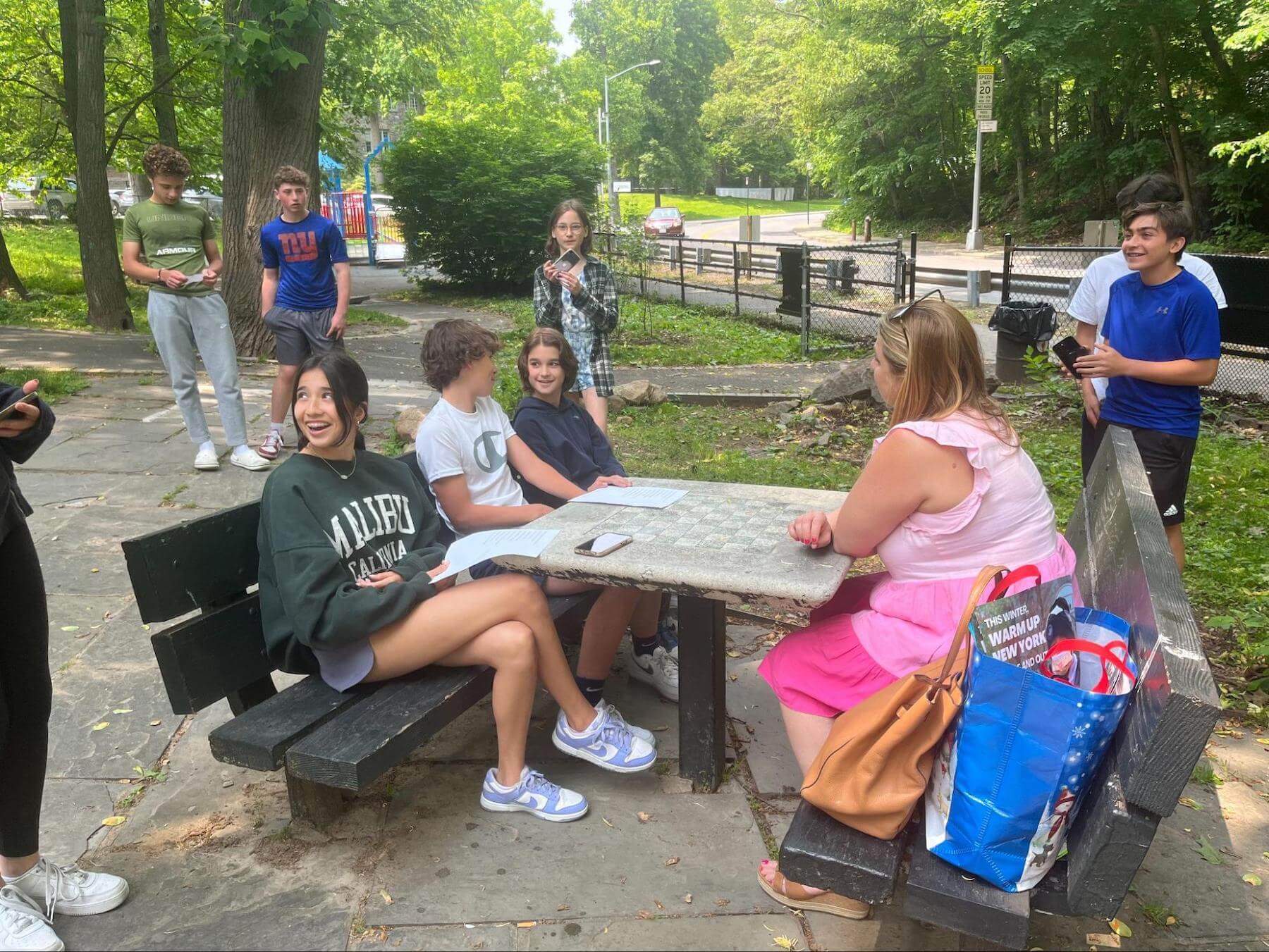 Ethical Culture Fieldston School 8th Graders interview a guest for their capstone outside.