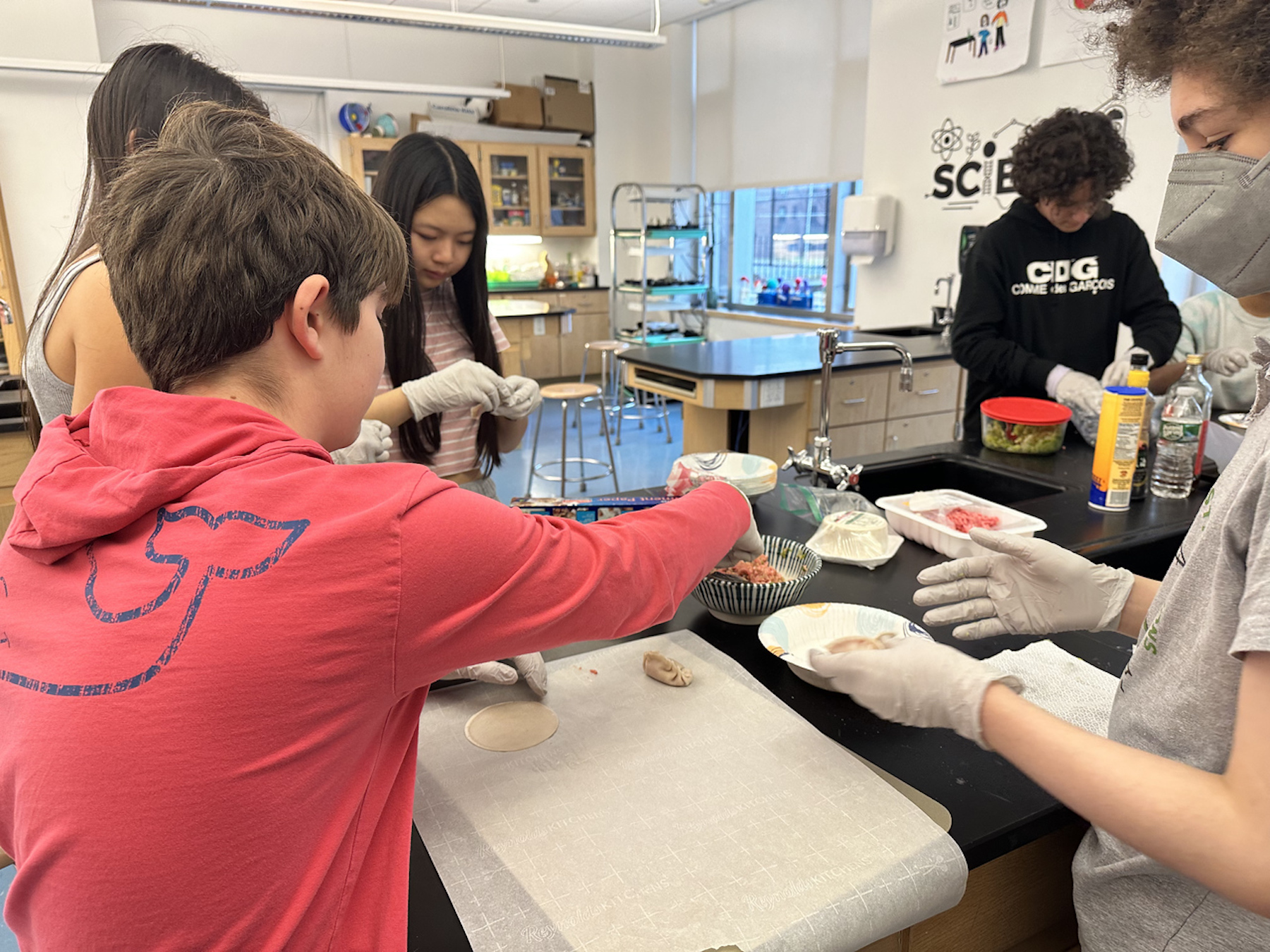 Group of Fieldston Middle students fill dumping wrappers.