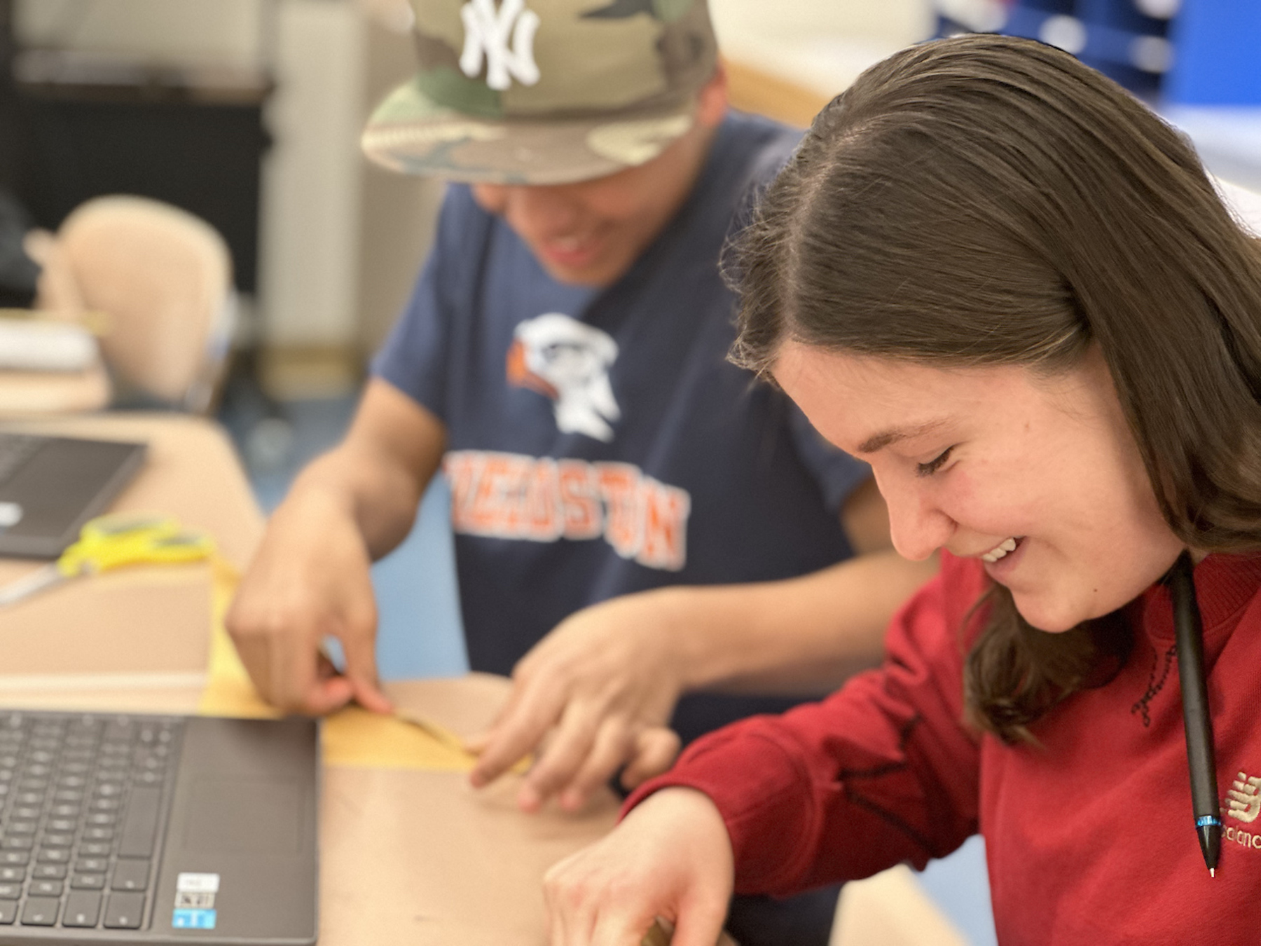 Student smiles as they fold rabbit origami.