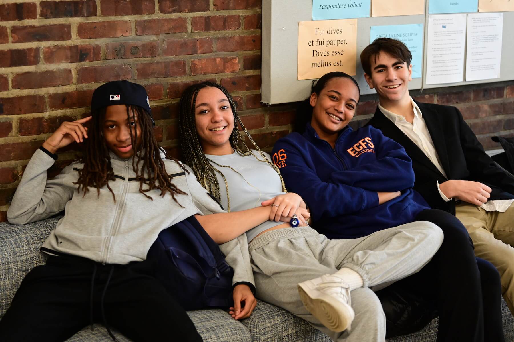 Four Ethical Culture FIeldston School Fieldston Upper Students sitting together smiling in Student Commons