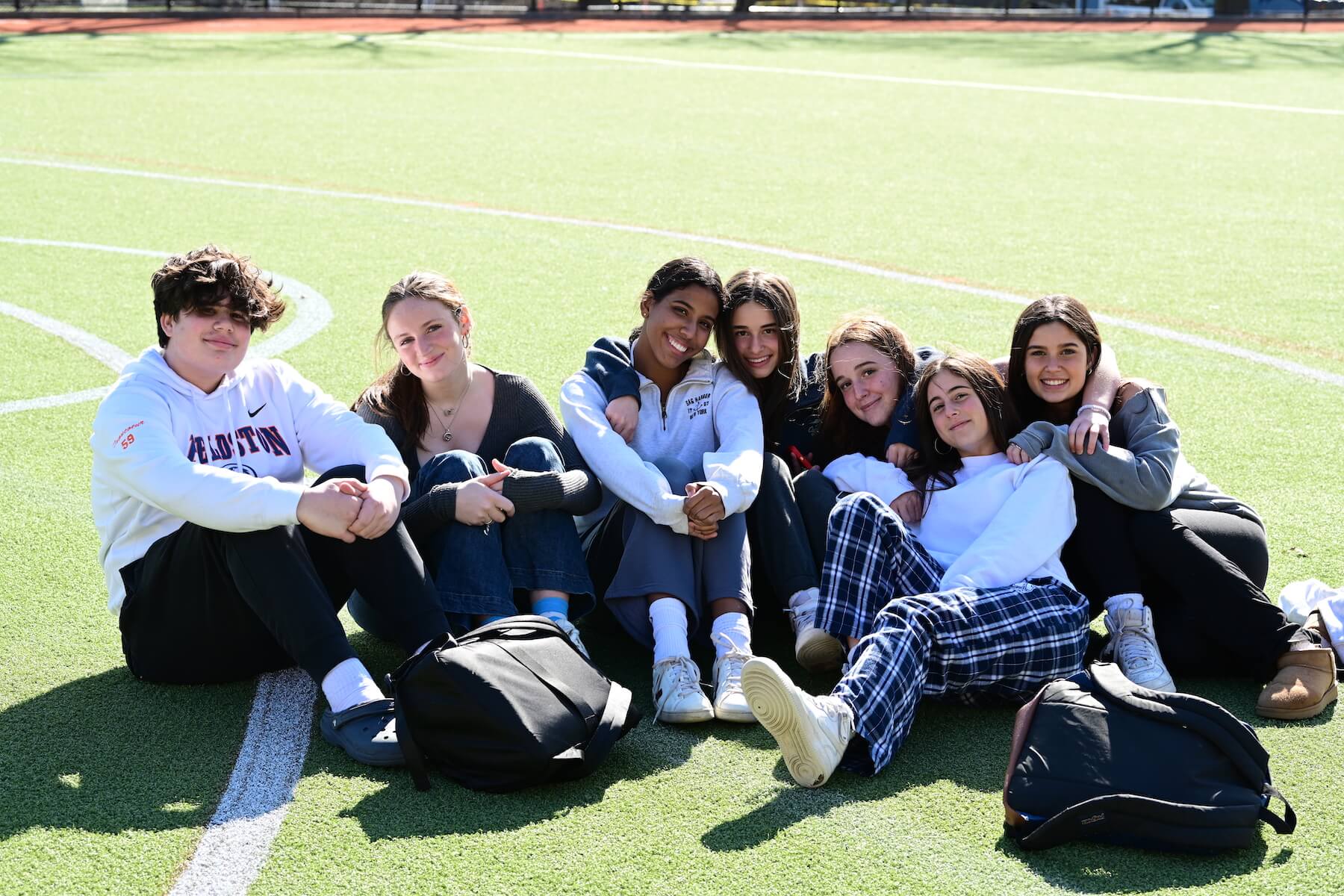 Group of Ethical Culture FIeldston School Fieldston Upper Students sitting together smiling on field