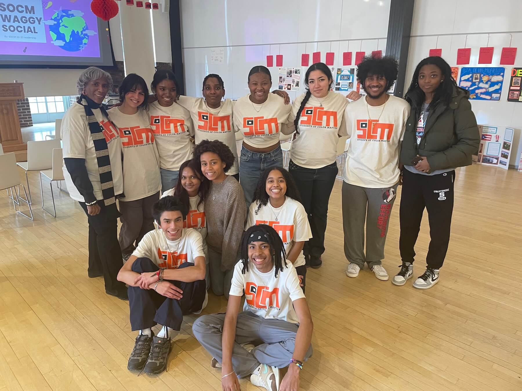 Ethical Culture Fieldston School's Students Of Color Matter (SOCM) group smile together at an event.