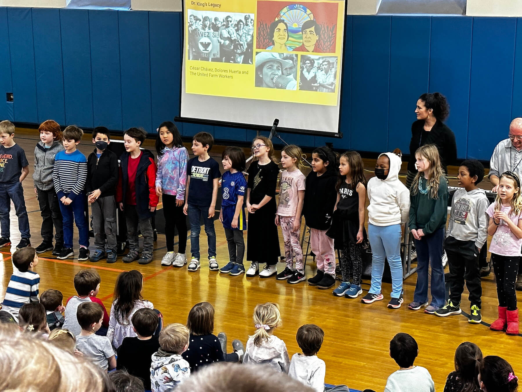 A group of Fieldston Lower students perform a song at assembly in a group.