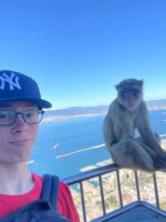 An Ethical Culture Fieldston Middle student stands next to a wild monkey in Gibraltar