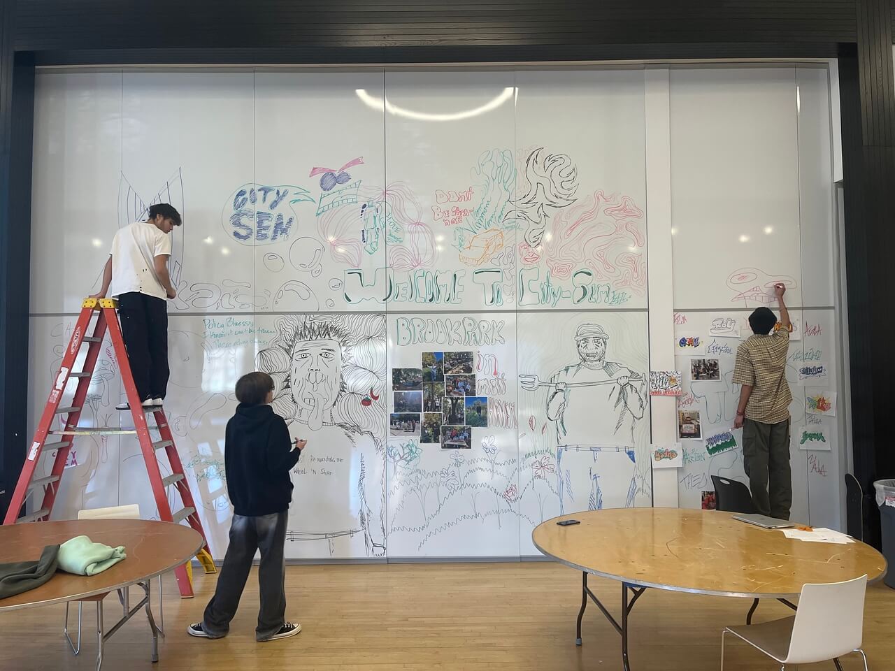 Photo of CitySem students working on mural whiteboard in the Student Commons.
