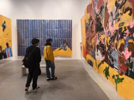 Two Fieldston Upper students view wall art in gallery space.