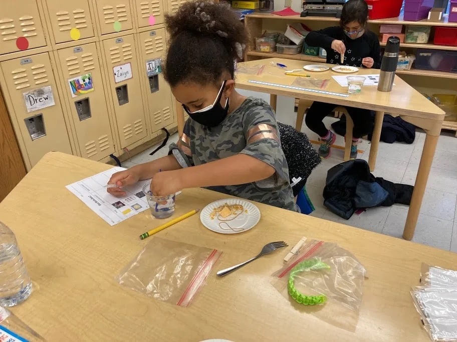 Student performs experiment at desk in classroom