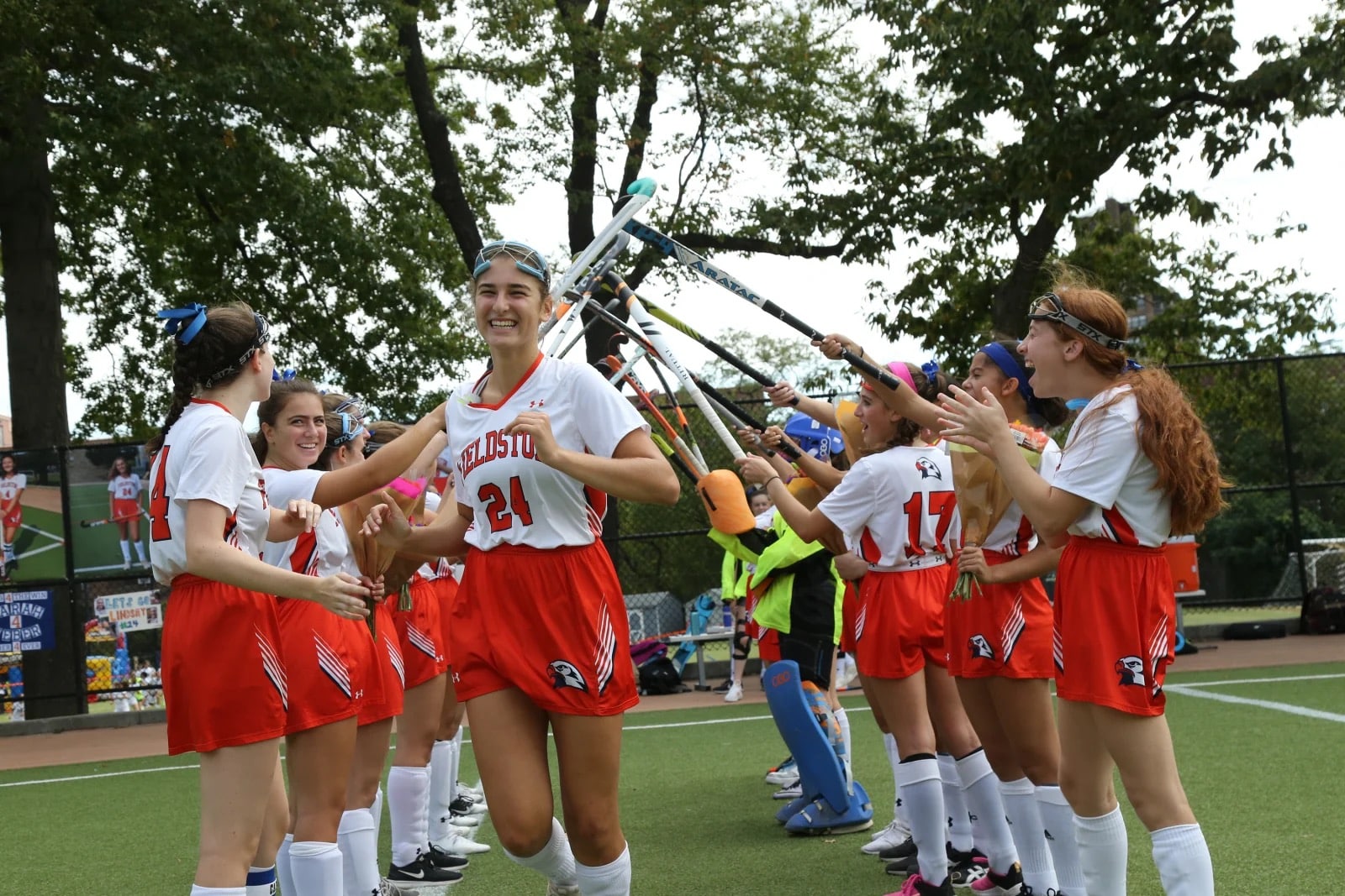 Varsity field hockey smiles as she runs through player tunnel before game