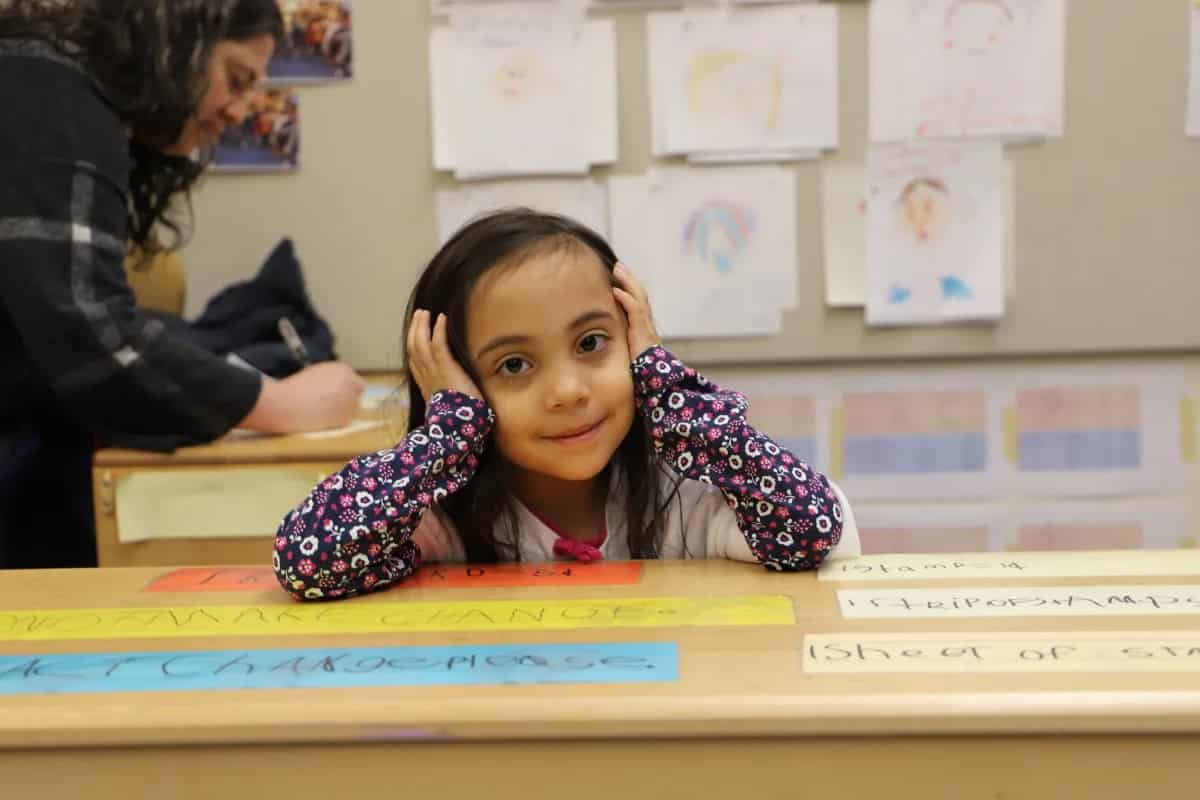 Student smiles at desk