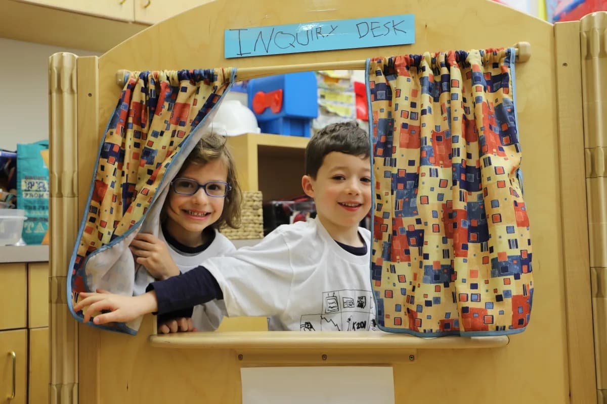 Students peer out of curtain of "Inquiry Desk" at makeshift post office