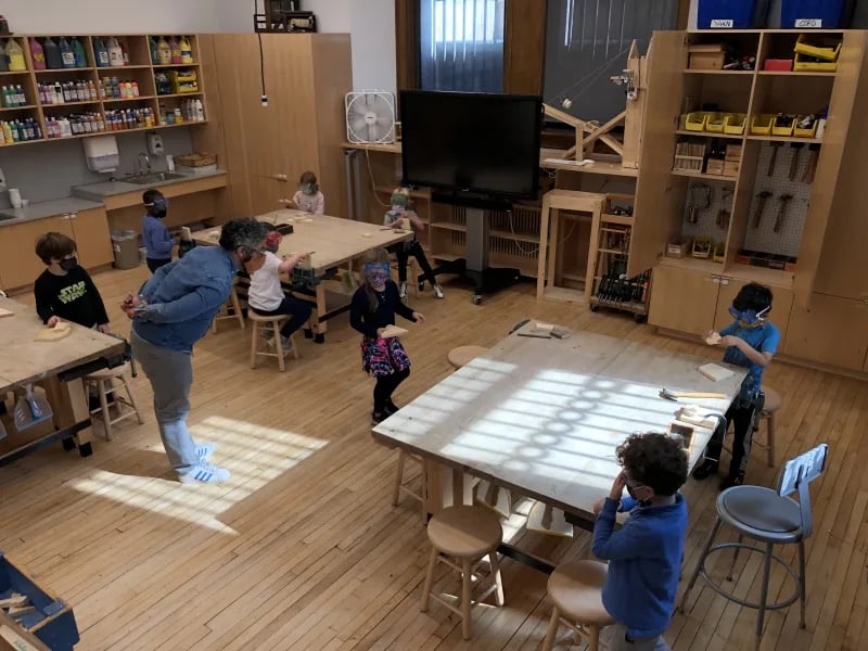 Students listen to teacher in Woodshop room