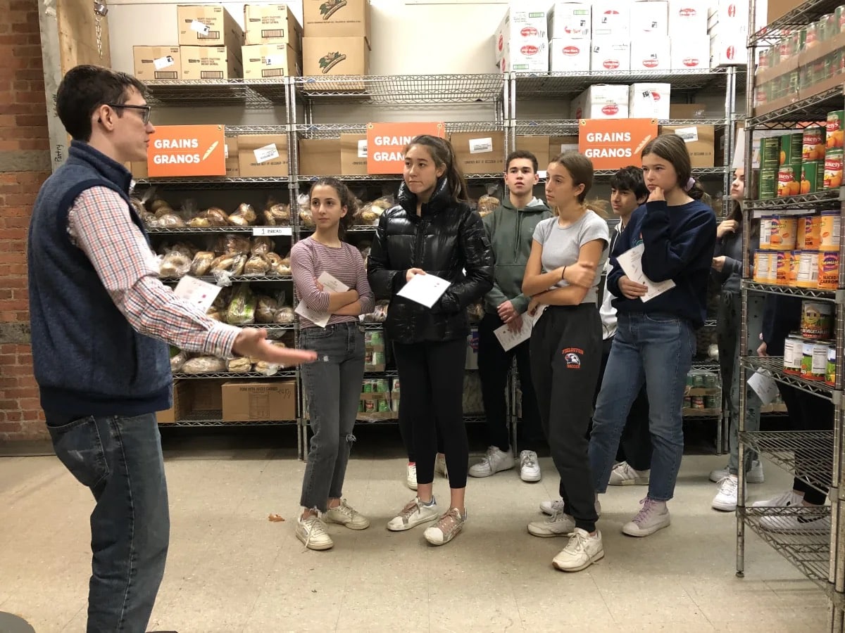 Students listen during tour of food pantry