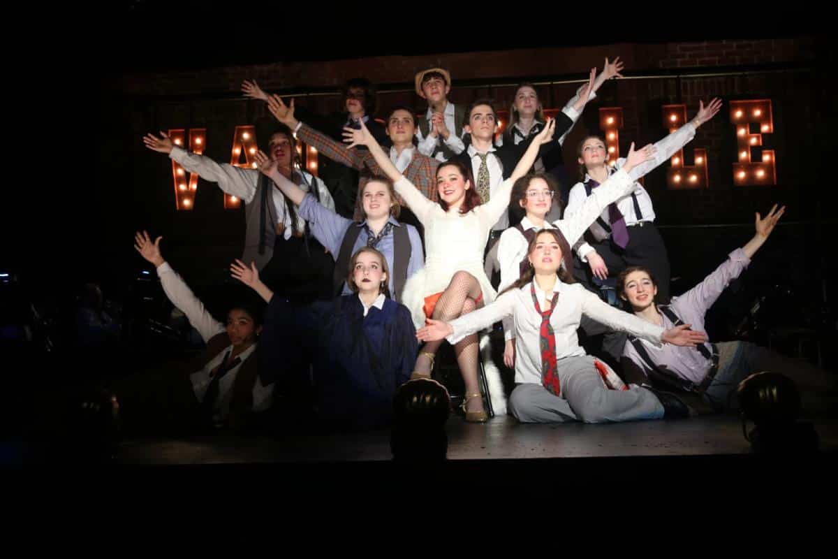 Student actors pose on stage during Chicago production