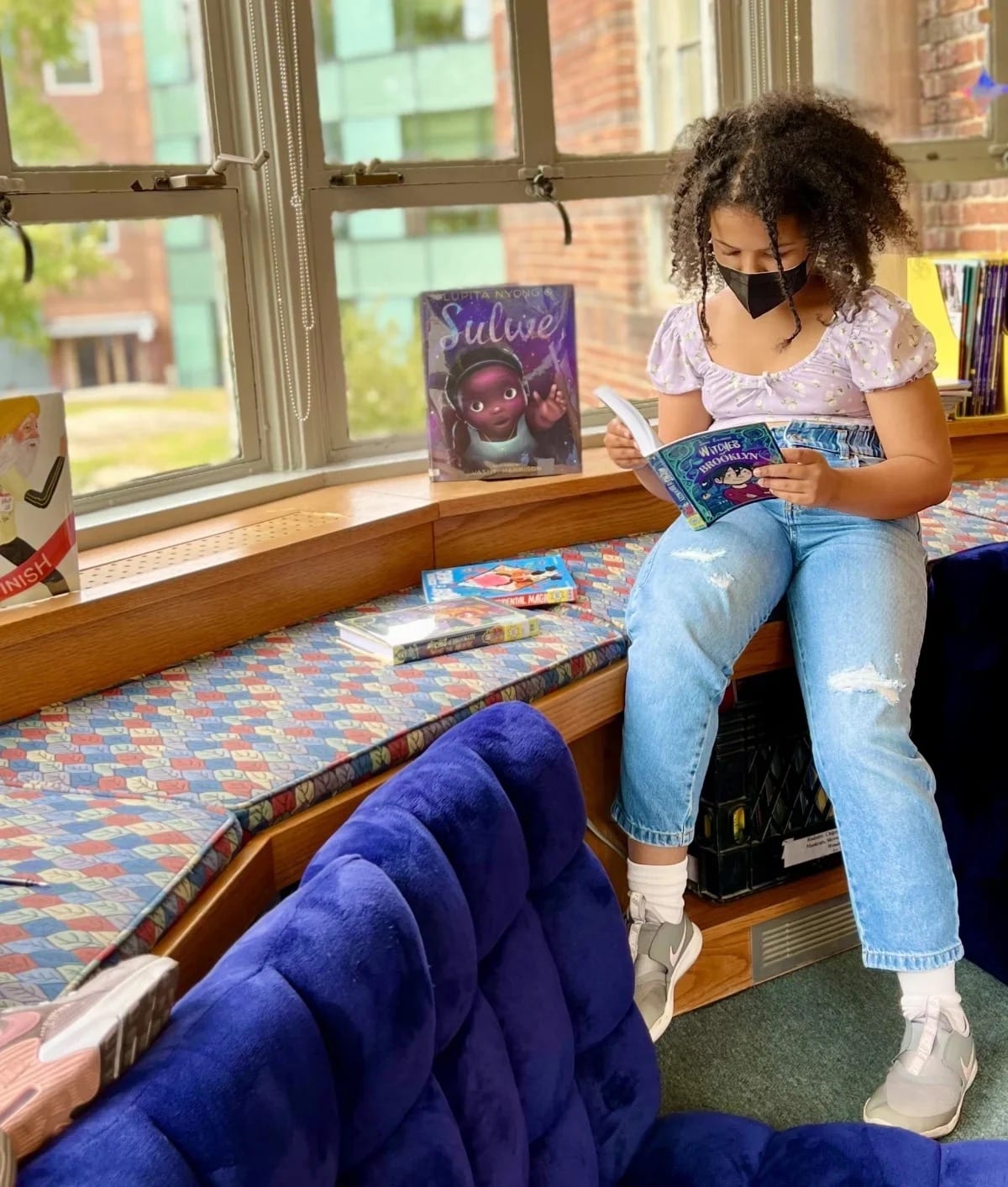 Student reads by window in Fieldston Lower library