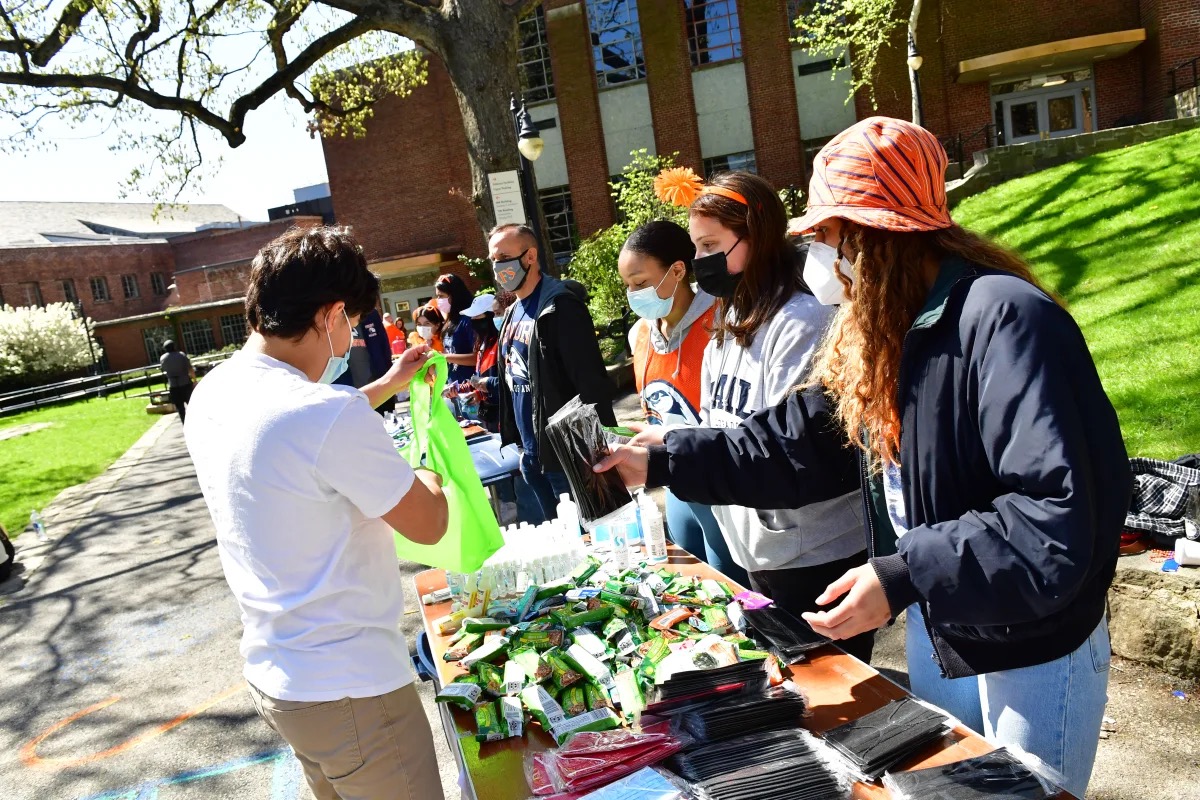 Students stand at table outside