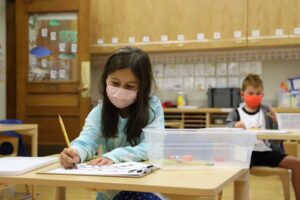 Student writes using pencil at desk