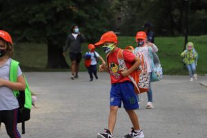 Masked student walks with backpack