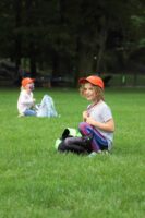 Student sits in grass, smiling