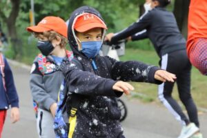 Student holds arms out in front while outdoors