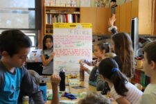 Student holds up signed classroom constitution