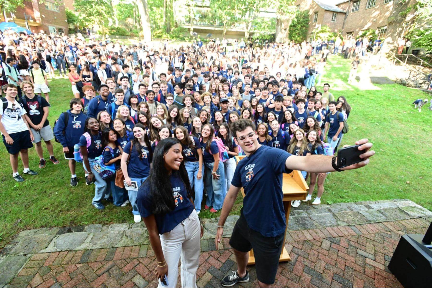Two Ethical Culture Fieldston School 12th Graders lead a group senior photo.