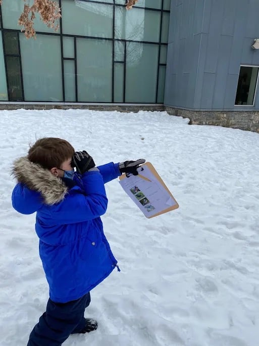 Student bird watching in the snow