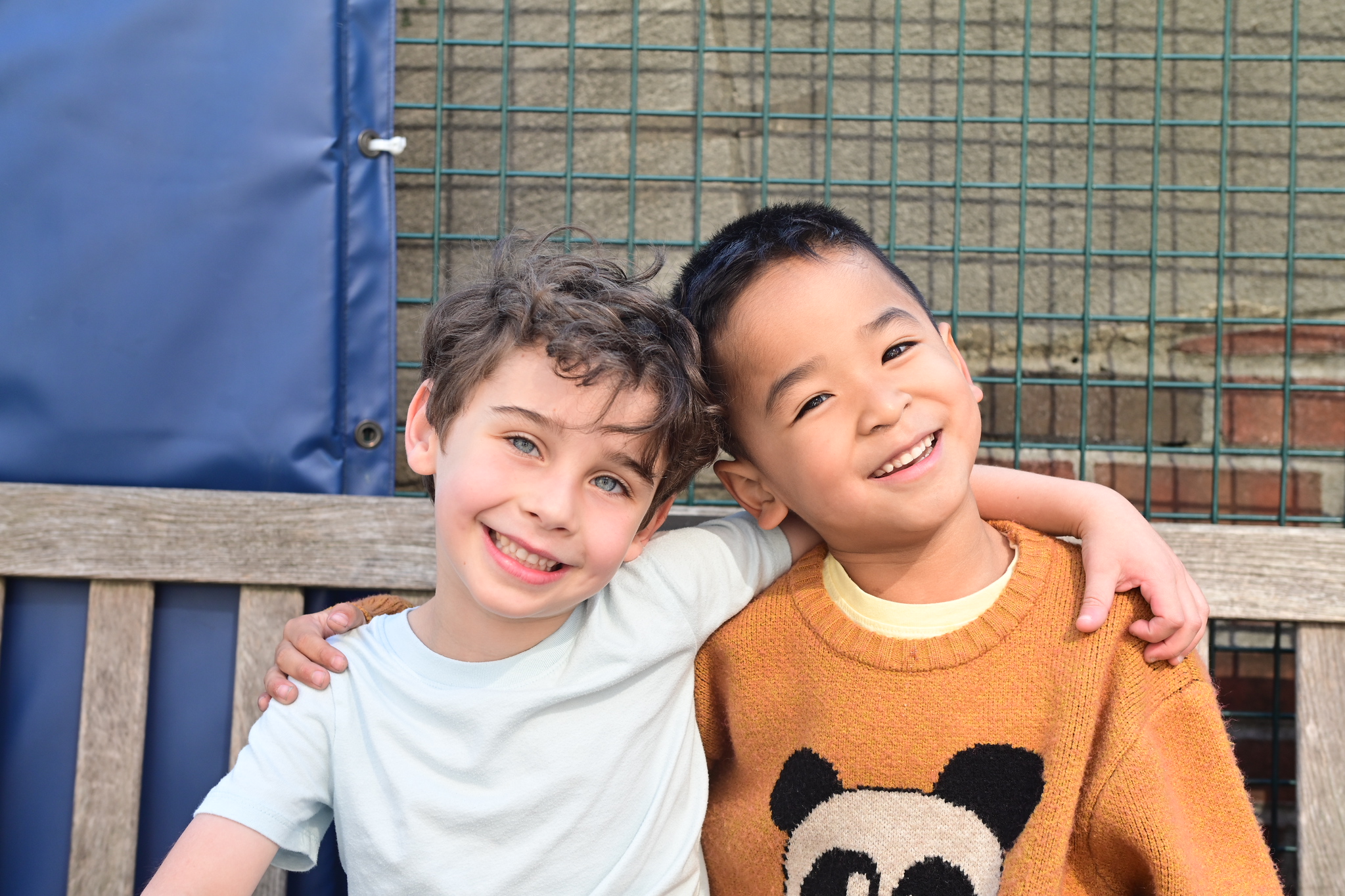 Ethical Culture students smile on the rooftop playground bench.