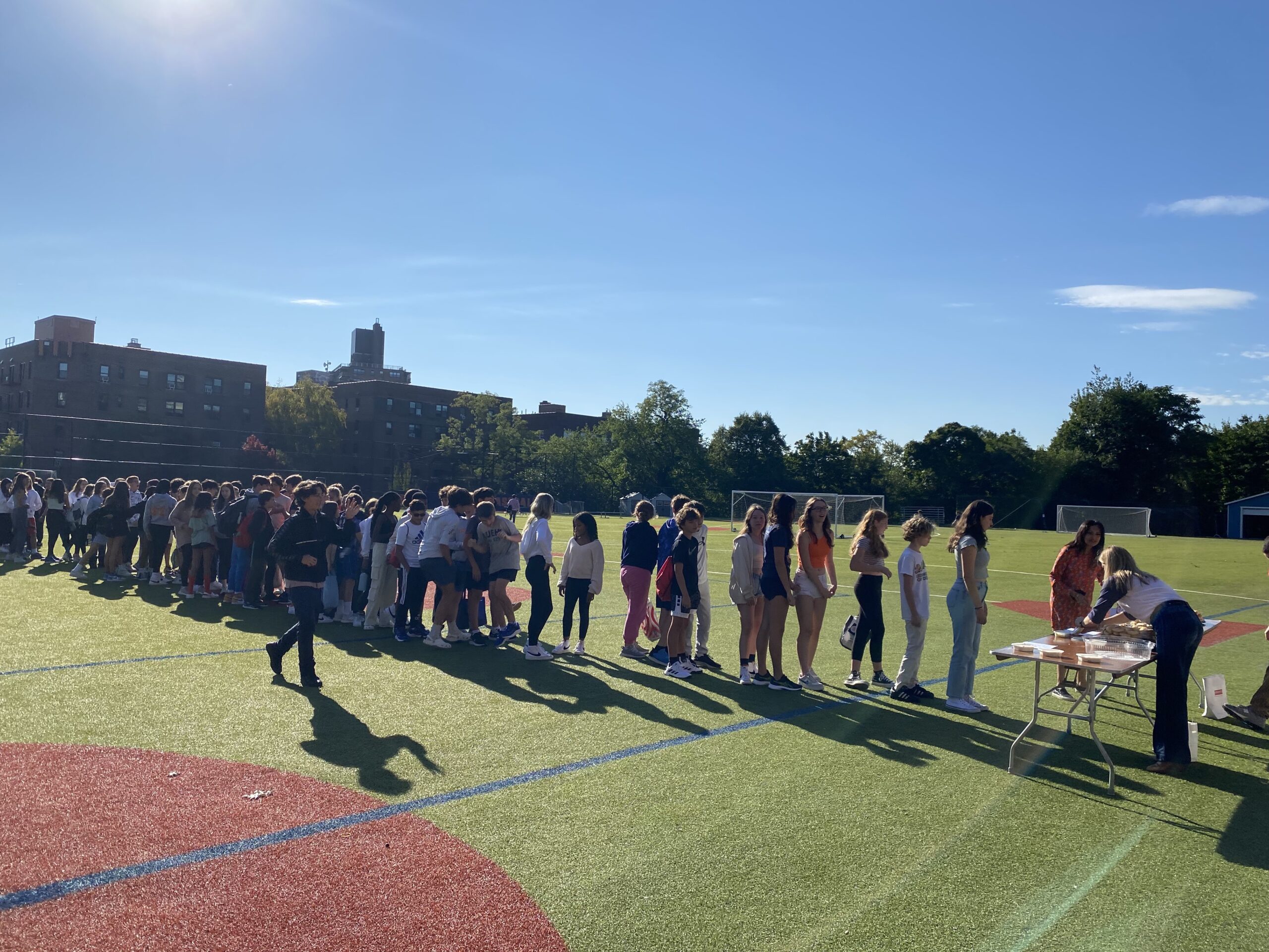 8th Graders at Fieldston Middle line up to get bialys on the Lower Field
