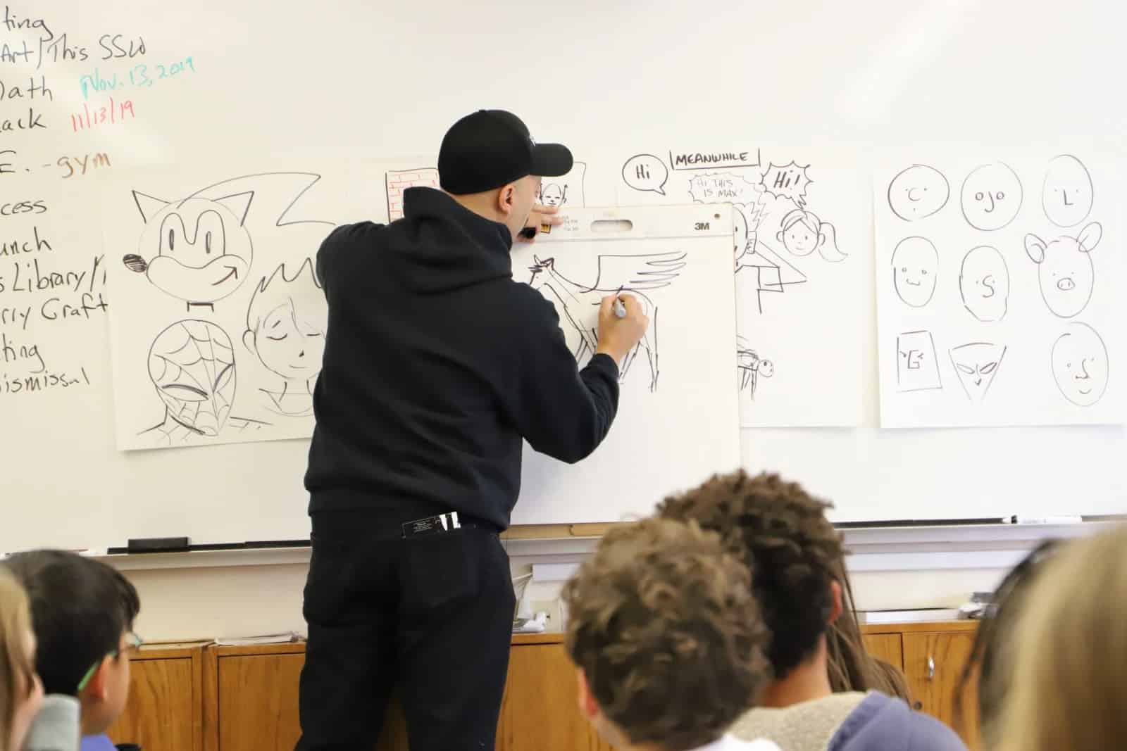 Craft draws animal on whiteboard while students look on