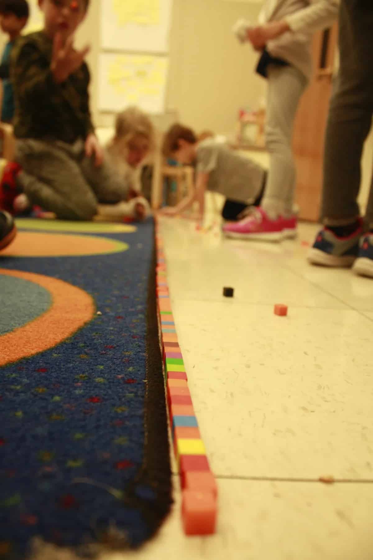 Photo of small cubes lining the classroom carpet