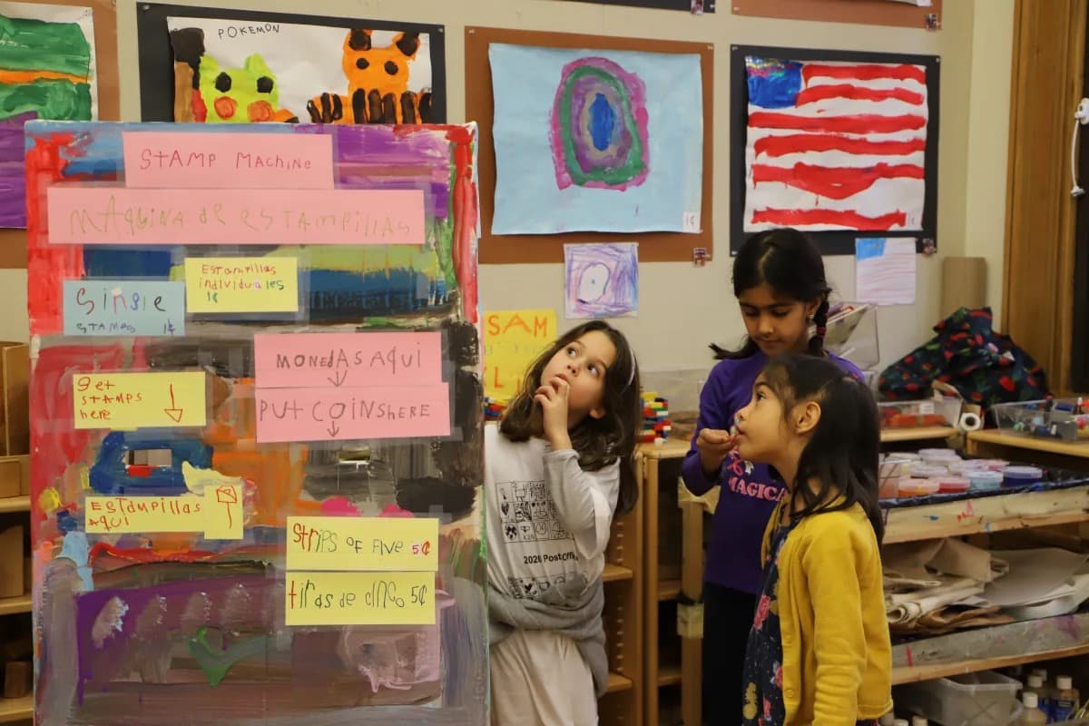 Students look at homemade stamp machine