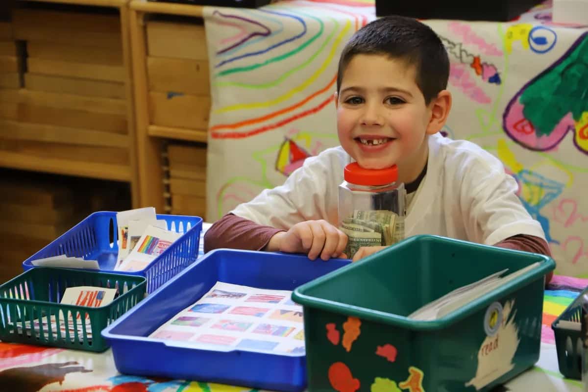 Student smiles at camera while working on post office project